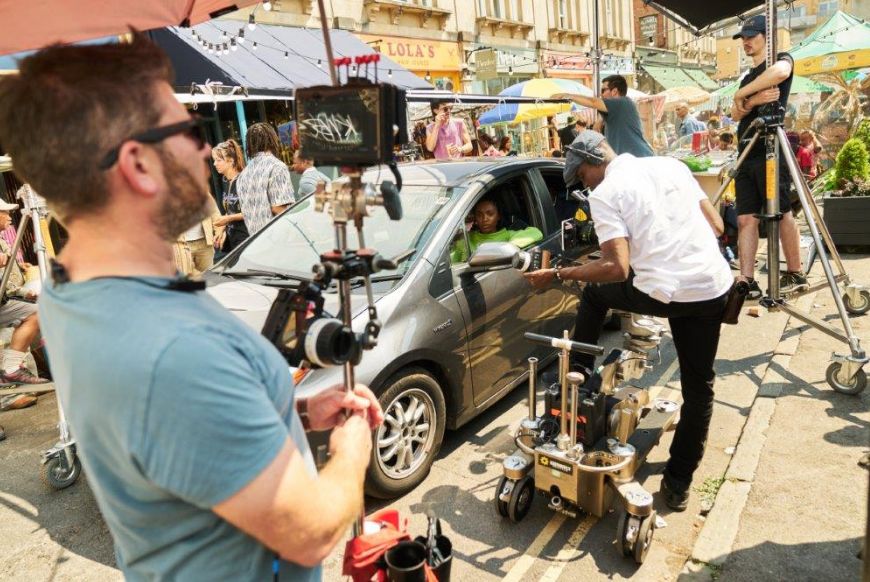 A camera crew filming in front of bristol cathedral
